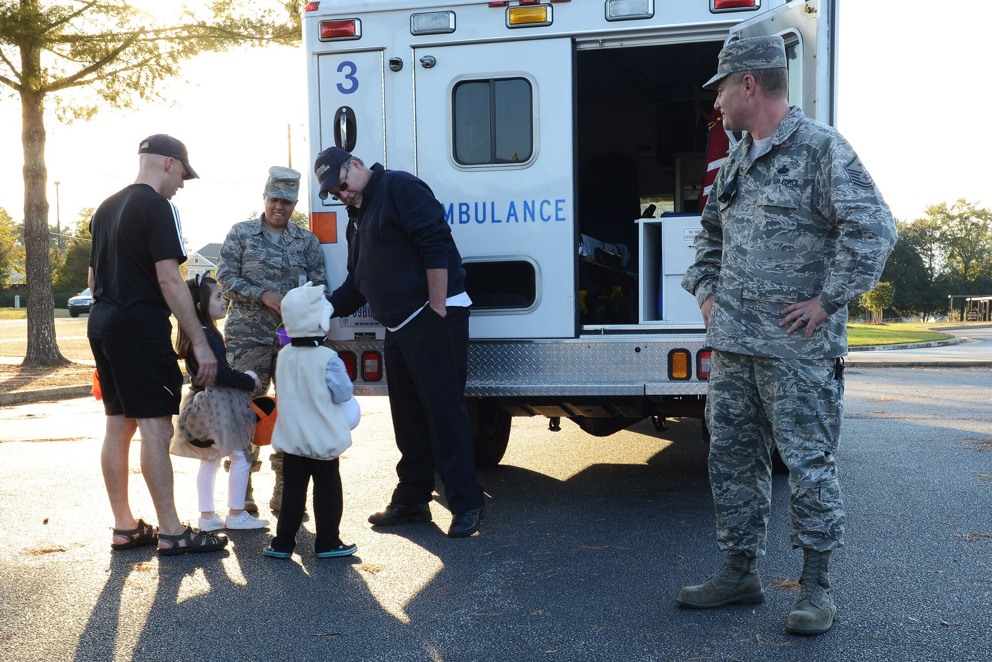 U.S. Air Force Staff Sgt. Rebecca Long, 20th Medical Operations Squadron medical technician, hands candy to trick-or-treaters at Shaw Air Force Base, S.C., Oct. 31, 2014. The first responders on base displayed their vehicles and handed out candy to children for Halloween. (U.S. Air Force photo by Airman 1st Class Diana M. Cossaboom/Released)