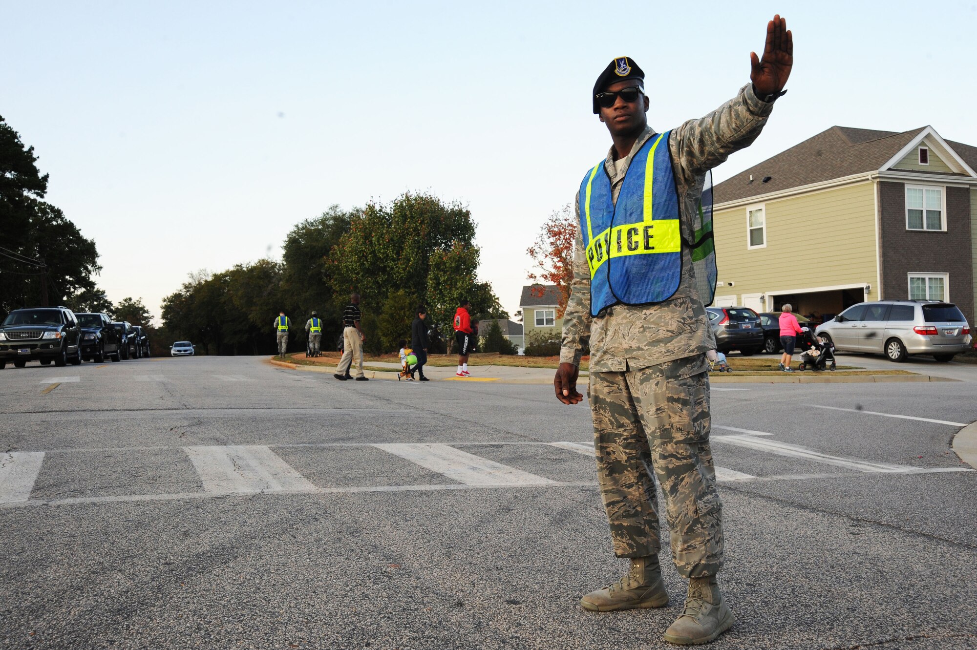 U.S. Air Force Airman 1st Class Tyler Frazier, 20th Security Forces Squadron patrolman, stops traffic to allow trick-or-treaters to cross the street at Shaw Air Force Base, S.C., Oct. 31, 2014. Airmen from different units volunteered to assist the 20th SFS with their Pumpkin Patrol program, which helps provide a safe trick-or-treating environment for children on base. (U.S. Air Force photo by Airman 1st Class Michael Cossaboom/Released)