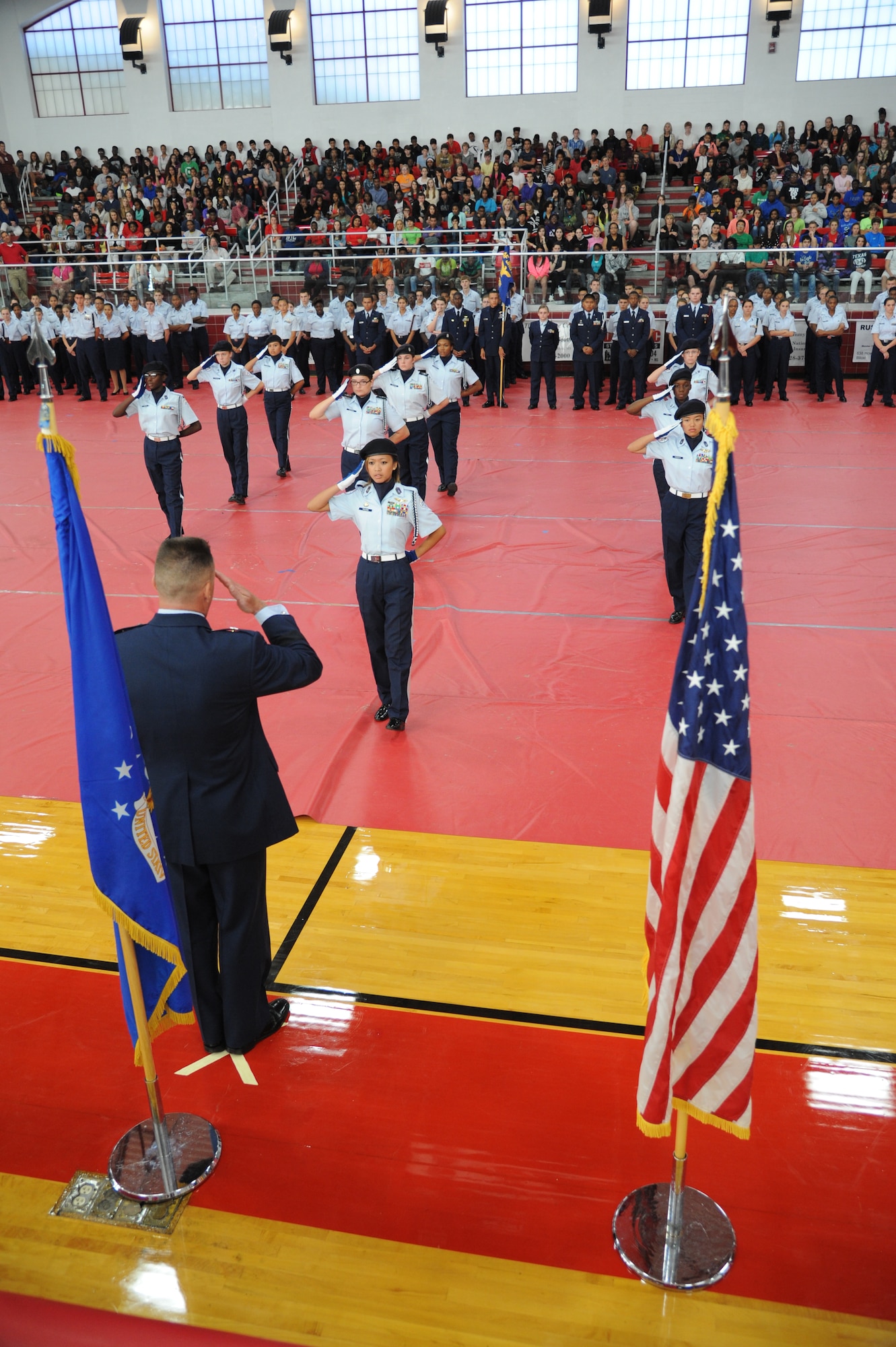 Brig. Gen. Higby, 81st Training Wing commander, returns a salute to members of the MS-781st Unarmed Exhibition Drill team as they prepare to perform their routine during the Biloxi High School Cadet Oath ceremony Oct. 30, 2014, at the Biloxi High School Sports Arena.  Higby delivered the oath to more than 100 Junior ROTC cadets. (U.S. Air Force photo by Kemberly Groue)