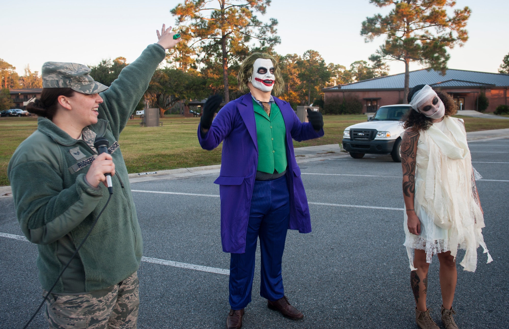U.S. Air Force Senior Airman Megan Rodgers, left, 23d Force Support Squadron fitness specialist, announces the finalists for best costume after a  Halloween zombie run Oct. 31, 2014, at Moody Air Force Base, Ga. Staff Sgt. Sharie Dawson, right, ended up winning, with Tech. Sgt. Matthew Conway, center, taking second place. (U.S. Air Force photo by Senior Airman Jarrod Grammel/Released)
