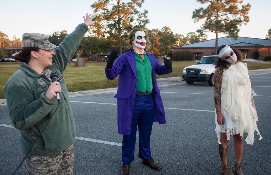 U.S. Air Force Senior Airman Megan Rodgers, left, 23d Force Support Squadron fitness specialist, announces the finalists for best costume after a  Halloween zombie run Oct. 31, 2014, at Moody Air Force Base, Ga. Staff Sgt. Sharie Dawson, right, ended up winning, with Tech. Sgt. Matthew Conway, center, taking second place. (U.S. Air Force photo by Senior Airman Jarrod Grammel/Released)

