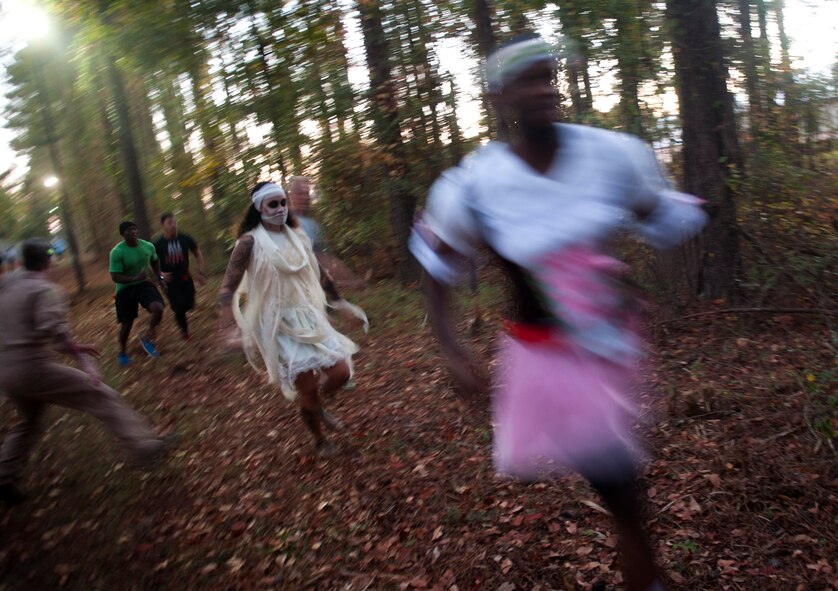 U.S. Air Force Staff Sgt. Sharie Dawson, center, a “zombie,” chases runners during a Halloween zombie run Oct. 31, 2014, at Moody Air Force Base, Ga. Runners started the race with three red ribbons, which were looped around their belts, to signify their “lives.” (U.S. Air Force photo by Senior Airman Jarrod Grammel/Released)
