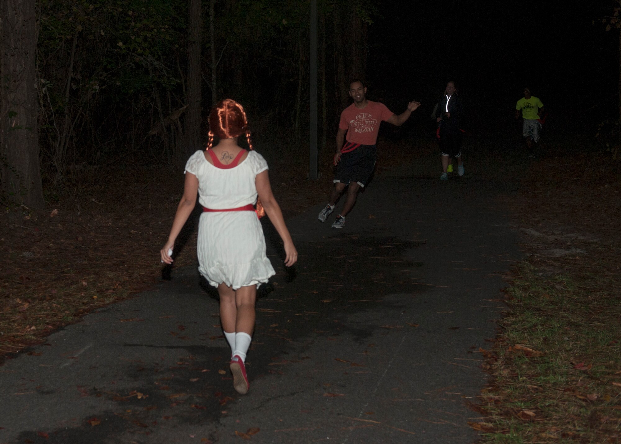 U.S. Air Force Staff Sgt. Shelly Sanders-Thaxton, a “zombie,” walks toward a runner during a Halloween zombie run Oct. 31, 2014, at Moody Air Force Base, Ga. Sanders-Thaxton  was one of about 10 “zombies” who were scattered throughout a 5K course with the goal of taking red ribbons, or lives, from the runners. (U.S. Air Force photo by Senior Airman Jarrod Grammel/Released)
