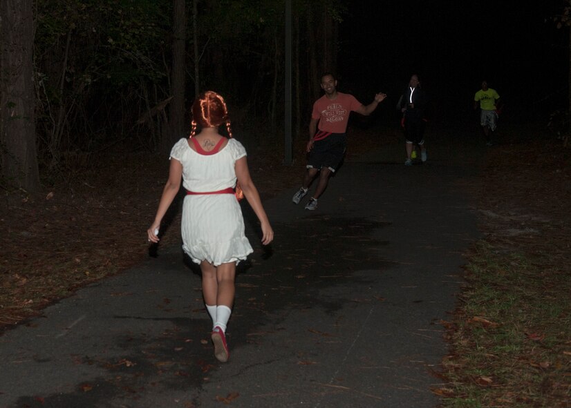 U.S. Air Force Staff Sgt. Shelly Sanders-Thaxton, a “zombie,” walks toward a runner during a Halloween zombie run Oct. 31, 2014, at Moody Air Force Base, Ga. Sanders-Thaxton  was one of about 10 “zombies” who were scattered throughout a 5K course with the goal of taking red ribbons, or lives, from the runners. (U.S. Air Force photo by Senior Airman Jarrod Grammel/Released)
