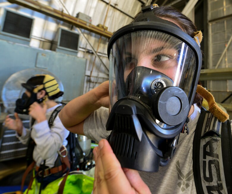 Senior Airman Erika Lis, 919th Special Operations Civil Engineer Squadron’s emergency management office, dons a gas mask during a training exercise Nov. 1 at Duke Field, Fla. The exercise tested the interoperability of fire and emergency management Airmen during a response to an aircraft fire/HazMat emergency scenario. (U.S. Air Force photo/ Tech. Sgt. Cheryl L. Foster)
