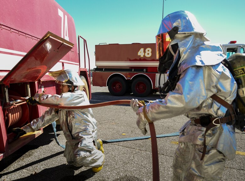 Senior Airman James Weslowski Jr, 919th Special Operations Civil Engineer Squadron, reels up a fire hose during a training exercise Nov. 1 at Duke Field, Fla. The exercise tested the interoperability of fire and emergency management Airmen during a response to an aircraft fire/HazMat emergency scenario. (U.S. Air Force photo/ Tech. Sgt. Cheryl L. Foster)