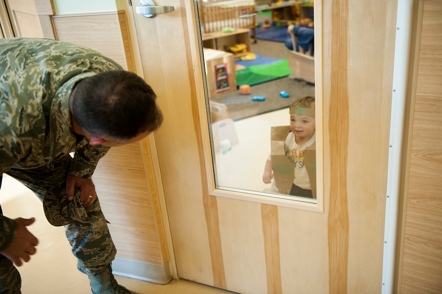 U.S. Air Force Chief Master Sgt. David Kelch, 23d Wing command chief, says hello to Allison Bobo, daughter of Capt. Victoria Bobo, 23d Operations Support Squadron, during a recycled materials costume contest at the Child Development Center II Oct. 31, 2014, at Moody Air Force Base, Ga. Because October is Energy Action Month, the 23d Civil Engineer Squadron held a recycled materials costume contest for children at the CDC between the ages of 6 weeks and 5 years old. (U.S. Air Force photo by Senior Airman Olivia Bumpers/Released)