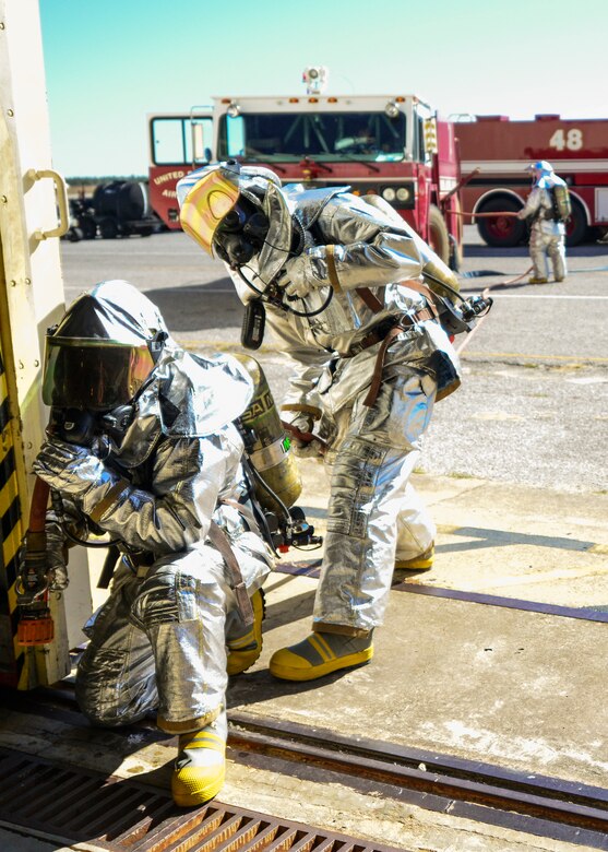Firefighters from 919th Special Operations Civil Engineer Squadron carry a hose into a hangar during a training exercise Nov. 1 at Duke Field, Fla. The exercise tested the interoperability of fire and emergency management Airmen during a response to an aircraft fire/HazMat emergency scenario. (U.S. Air Force photo/ Tech. Sgt. Cheryl L. Foster)