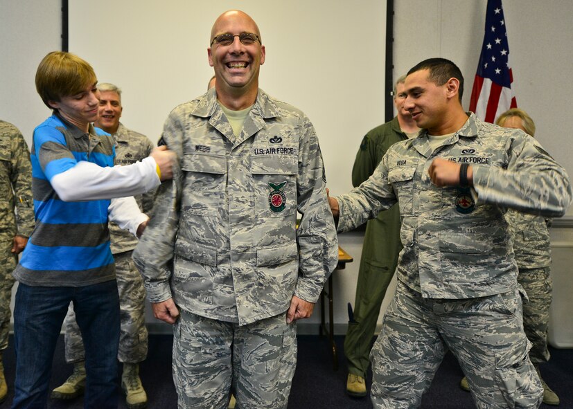 Chief Master Sgt. Pete Webb, 919th Special Operations Civil Engineer Squadron, winces as his son, Spencer, and Senior Airman Oscar Vega Jr., 919th SOCES Fire Department’s lowest ranking member, tack on his new stripes during his ceremony Nov. 2 at Duke Field. Webb is the newest chief on Duke Field and is going to be referred to as the ”Jeep Chief” until a new chief master sergeant is promoted. (U.S. Air Force photo/Tech Sgt. Cheryl L. Foster)