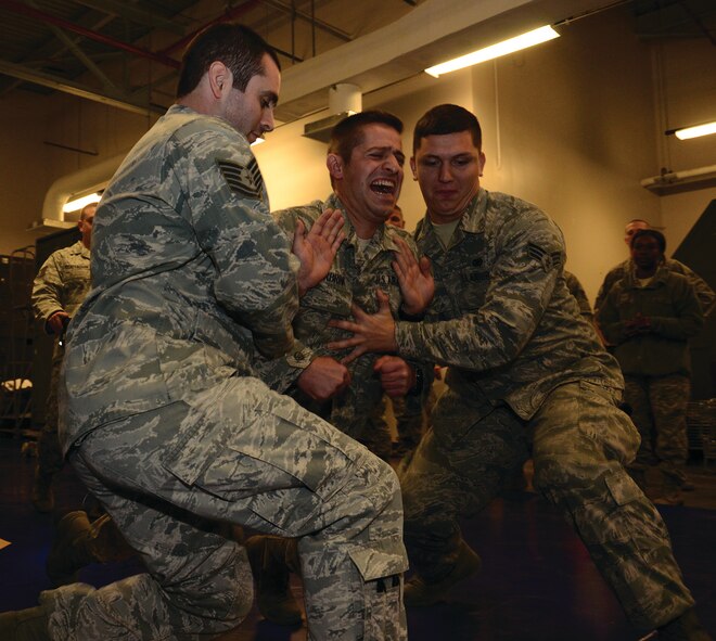 WRIGHT-PATTERSON AIR FORCE BASE, Ohio -  445th Security Forces Squadron reservists Tech. Sgt. Joshua McCrabb and Senior Airman Jalen McMahan use a TASER on Senior Airman Brendon Burbrink during the Oct. 5, 2014 TASER training. Electrodes from a TASER were attached to Burbink’s back and for five seconds he felt what it was like to be on the receiving end. The TASER gun fires probes that can stun a person for a period of up to five seconds, allowing security forces personnel time to seize control of a potentially violent situation. (U.S. Air Force photo/Senior Airman Devin Long)