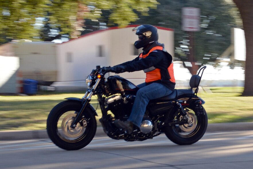 A motorcycle rider cruises down a road cruises down a road on Barksdale Air Force Base, La., Oct. 31, 2014. Before a 137-mile ride around the local area as part of Cajun Rumble, riders were divided into groups with each group having an experienced leader who would convey hand signals to the other members for safety. (U.S. Air Force photo/Airman 1st Class Curt Beach) 