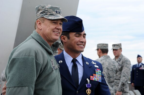 Air Force District of Washington Commander Maj. Gen. Darryl Burke poses for a photo with Tech. Sgt. Christopher Ferrell after a Purple Heart Medal presentation ceremony at the Air Force Memorial in Arlington, Va., Oct. 31, 2014. Ferrell was presented the Purple Heart Medal for injuries he received while conducting a direct action operation in Sangin, Afghanistan, in 2009. Ferrell is an explosive ordnance disposal technician assigned to the 11th Civil Engineer Squadron at Joint Base Andrews, Md. (U.S. Air Force photo/Master Sgt. Tammie Moore)