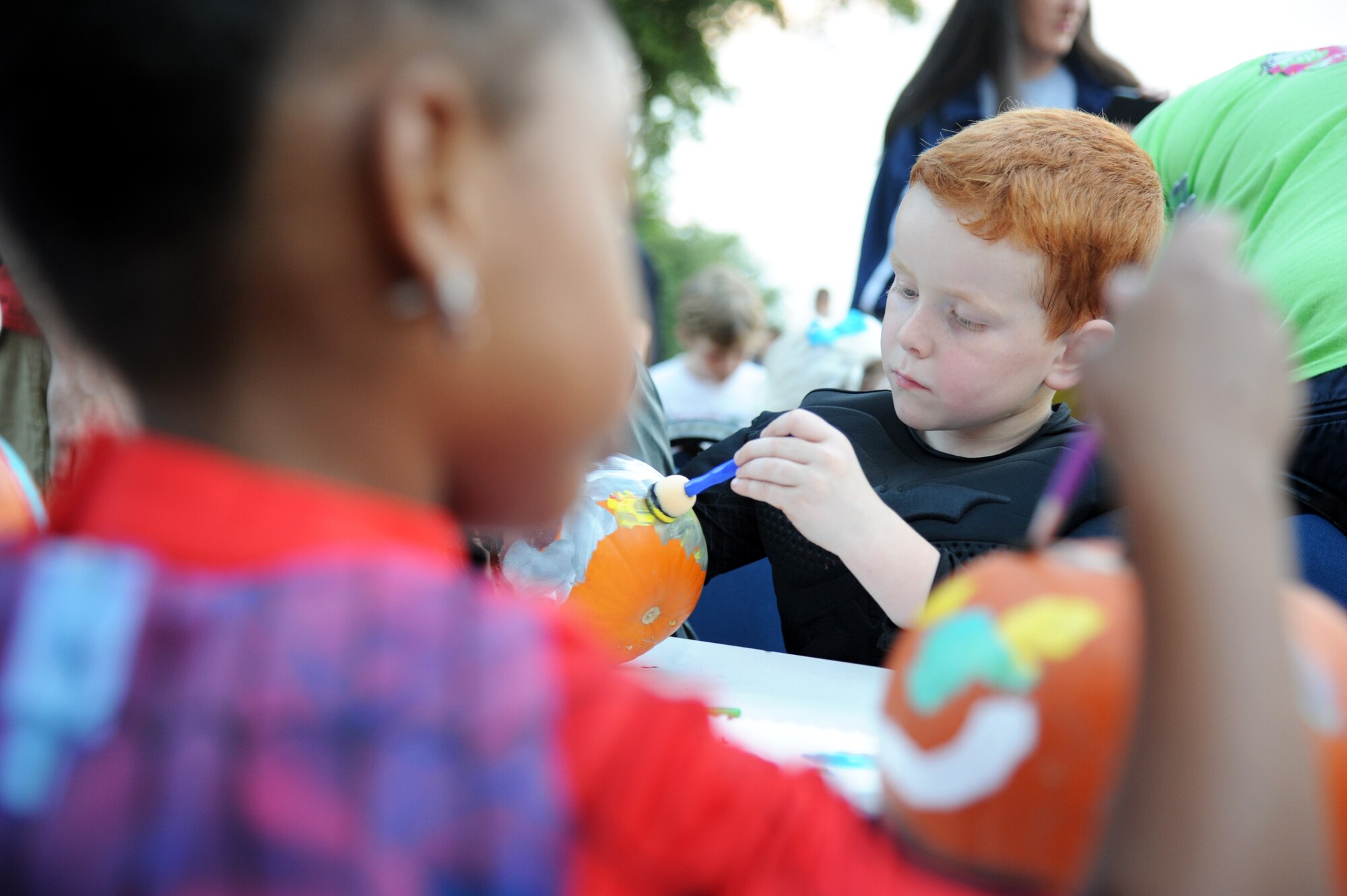 The son of Staff Sgt. Douglas Fraites, 85th Engineering Installation Squadron, paints a pumpkin during the 2nd Annual 85th EIS Trunk-Or-Treat Oct. 29, 2014, at Maltby Hall, Keesler Air Force Base, Miss.  The event also included a costume contest and trunk-or-treating.  (U.S. Air Force photo by Kemberly Groue)