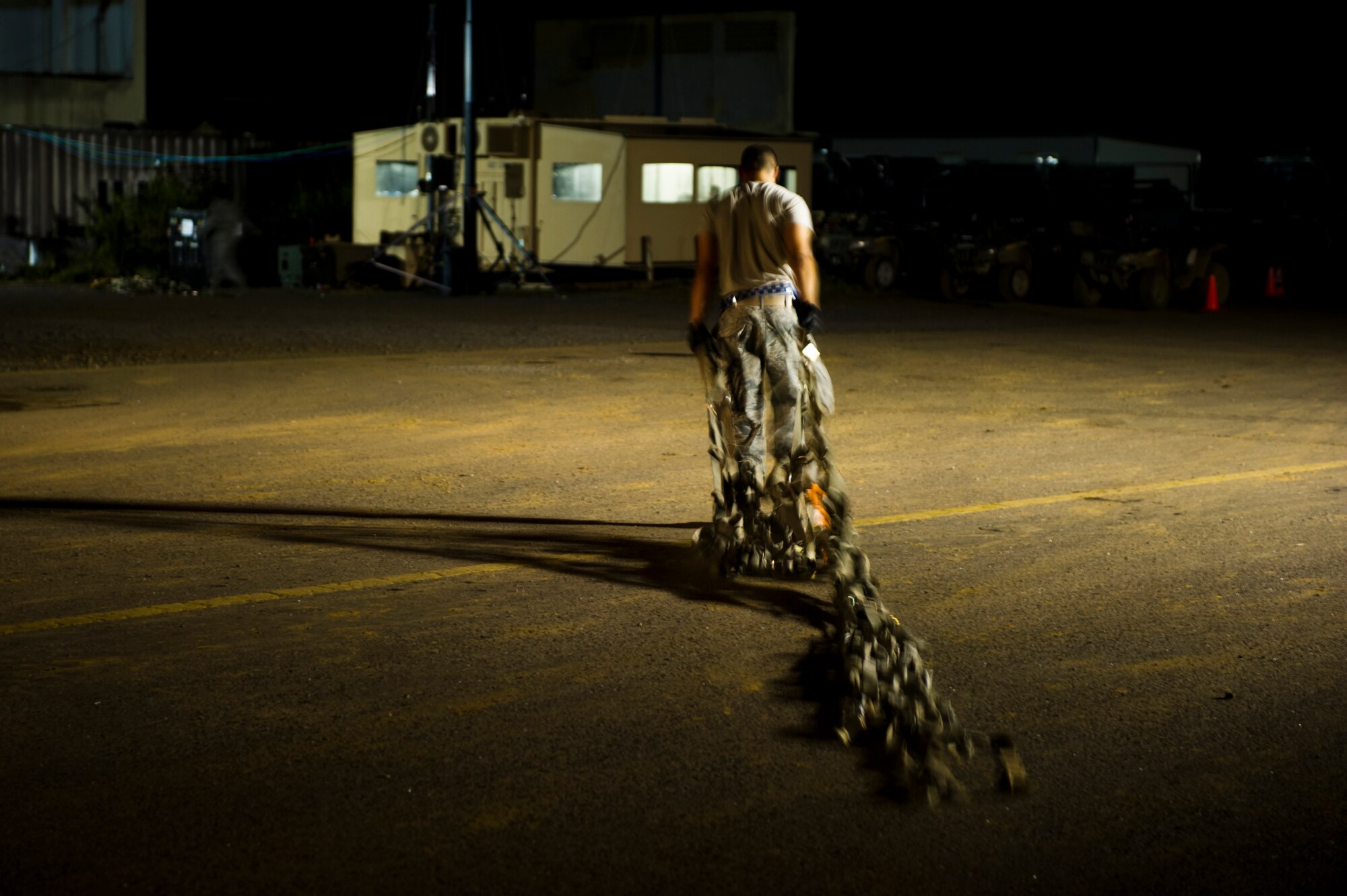 U.S. Air Force Staff Sgt. Luryan Camacho, an aerial porter of the Joint Task Force-Port Opening of the 621st Contingency Response Wing stationed at Joint Base McGuire-Dix-Lakehurst, N.J., drags cargo nets out of the cargo yard here, during Operation United Assistance, Nov. 2, 2014. OUA is a Joint Forces Command-led operation to provide command and control, logistics, training and engineering support to the U.S. government’s efforts to contain the Ebola virus outbreak in West African nations. (U.S. Air Force photo by Staff Sgt. Gustavo Gonzalez/Released)