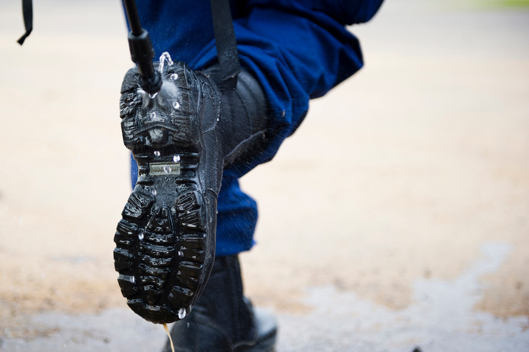 Members of the U.S. Public Health Service cleanse their boots after returning here, during Operation United Assistance, Oct. 31, 2014. OUA is a U.S. Joint Forces Command-led operation to provide command and control, logistics, training and engineering support to the U.S. government’s efforts to contain the Ebola virus outbreak in West African nations. (U.S. Air Force photo by Staff Sgt. Gustavo Gonzalez/Released)