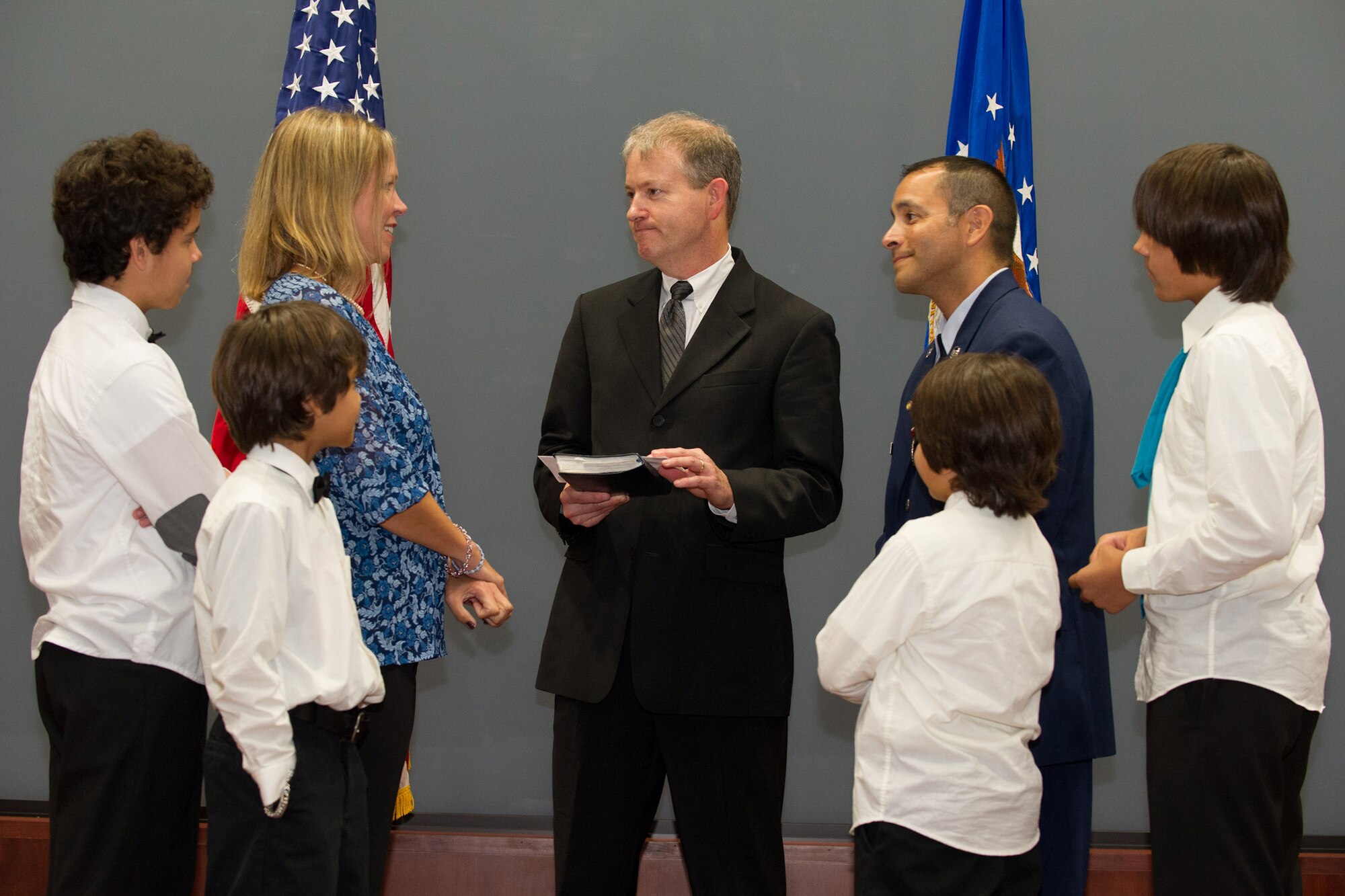 Rev. Mark Ragsdale, pastor of The Church of Viera near Patrick AFB, Fla., administers wedding vows to Master Sgt. Thomas Arevalos (right) and his wife, Melissa (left) as their four sons serve as witnesses.  Arevalos surprised his wife with the vow renewal at his retirement ceremony Oct. 17, 2014.  (U.S. Air Force photo by Cory Long)