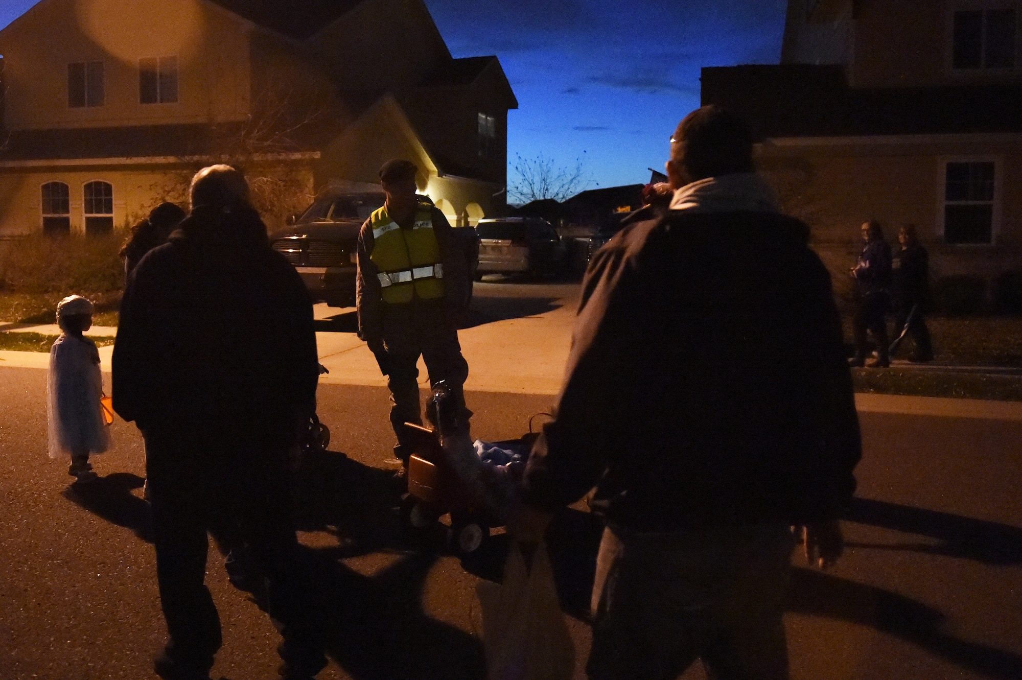 A 460th Security Forces Squadron member assists trick-or-treaters in base housing Oct. 31, 2014, on Buckley Air Force Base, Colo. Members of the 460th Security Forces Squadron and volunteers patrolled base housing during Halloween, providing a safer environment for children to trick-or-treat in with added security and traffic control. (U.S. Air Force photo by Airman 1st Class Samantha Saulsbury/Released)
