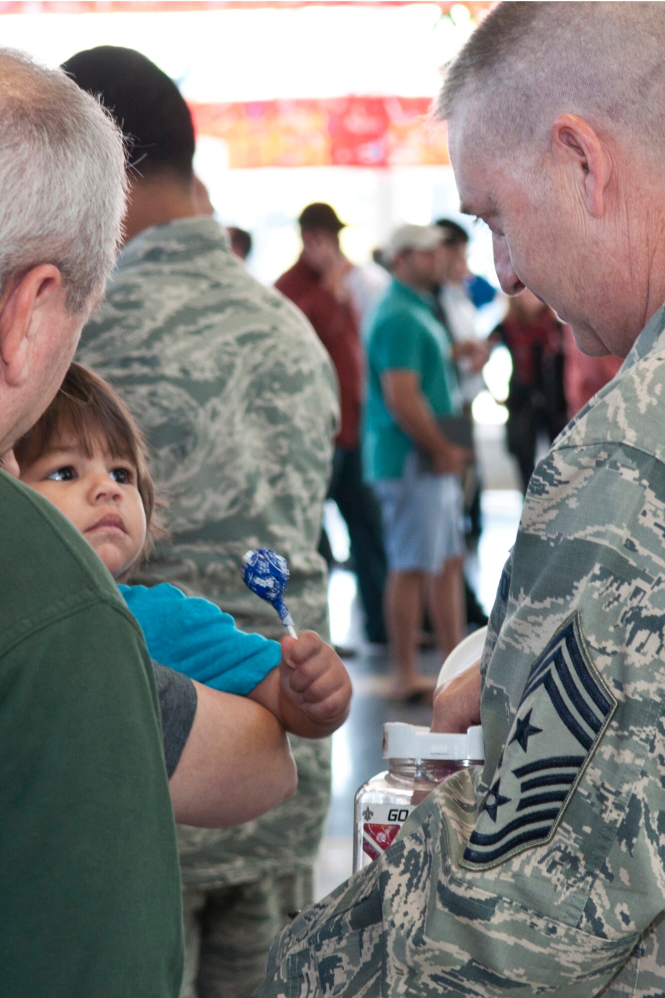 U.S. Air Force Chief Master Sgt. Randy Noble passes out lollipops to waiting family and friends of members of the 307th Security Force Squadron, Oct. 29, 2014, Shreveport, La. Noble is the 307th Bomb Wing command chief and is there to greet the squadron members as they returned from a six-month long deployment in support of Operation Enduring Freedom. (U.S. Air Force photo by Master Sgt. Dachelle Melville/Released)