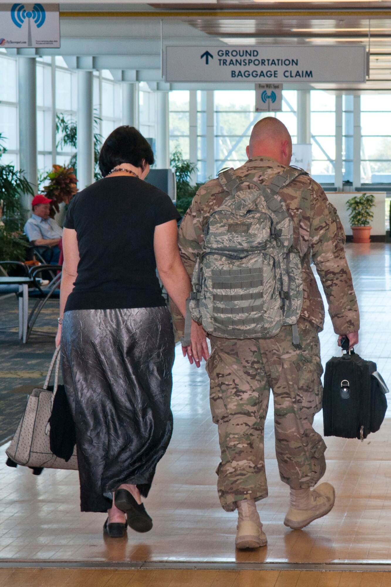 U.S. Air Force Tech. Sgt. Jason Fruge walks with his wife to baggage claim after his return from a deployment, Oct. 29, 2014, Shreveport, La. Fruge is assigned to the 307th Security Forces Squadron at Barksdale Air Force Base, La., and deployed in support of Operation Enduring Freedom. (U.S. Air Force photo by Master Sgt. Dachelle Melville/Released)