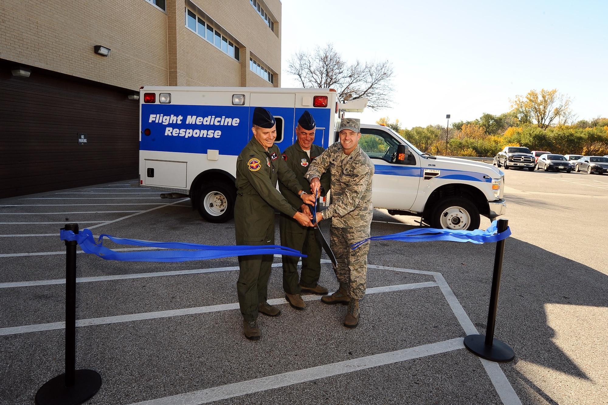 (L-R)  U.S. Air Force Col. Thatcher Cordon, 55th Aerospace Medicine Squadron commander, U.S. Air Force Col. Mark Williamson, 55th Wing vice commander and U.S. Air Force Col. Stephen Mounts, 55th Medical Group commander, ceremoniously cut a blue ribbon signifying the opening of the 55th Aerospace Medicine Squadron’s new location at Ehrling Bergquist Clinic Oct. 29, Offutt Air Force Base, Neb.  The 55th Aerospace Medicine Squadron was originally located at Ehrling Bergquist but was moved behind the base gates in February of 1997.  (U.S. Air Force photo by Josh Plueger/Released)