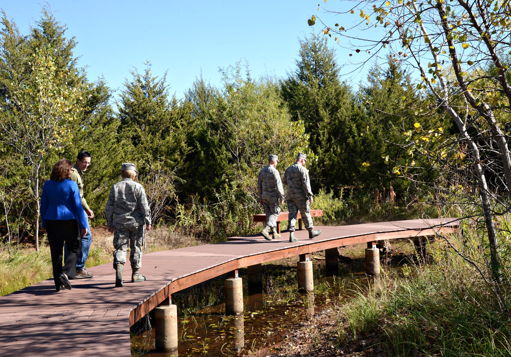 John Krupovage, Natural Resources manager with the 72nd Civil Engineering Squadron, second from left, talks about the new boardwalk at Prairie Pond with  Cathy Scheirman, 72nd ABW/CE director, and Col. Lea Kirkwood, 72nd Air Base Wing vice commander. Walking ahead of them are Col. Christopher Azzano, 72nd ABW and Tinker installation commander, left, and Col. Gerald McCray, 76th Aircraft Maintenance Group commander. The boardwalk and deck at the pond on the Scissortail Trail was officially opened Wednesday. The project to restore the dilapidated deck and boardwalk was recently completed by a group of volunteers from across base. (Air Force photo by Kelly White)