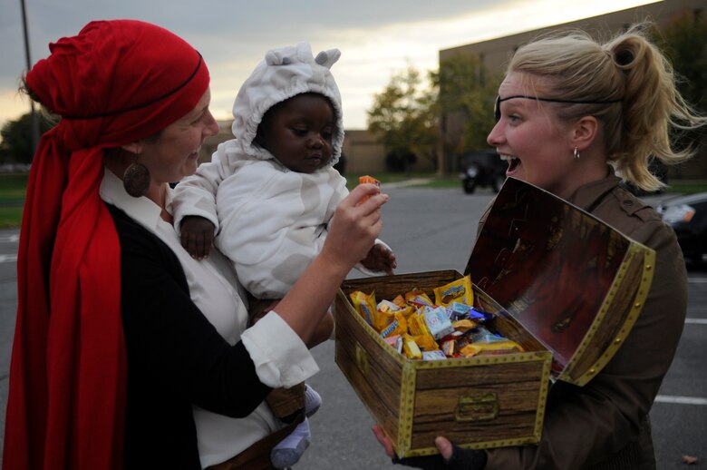Capt. Erika Wonn, 11th Wing Public Affairs officer, left, and 1st Lt. Alexandra Ellis, 11th Comptroller Squadron financial management analysis deputy, right, give candy to a “Trunk or Treat” attendees on Joint Base Andrews, Md., Oct. 30, 2014. JBA fire department and explosive ordinance disposal, the Combined Federal Campaign, Military Family Support Center and Company Grade Officer Council were some organizations handing out candy and Halloween toys to military families. (U.S. Air Force photo/ Senior Airman Nesha Humes)