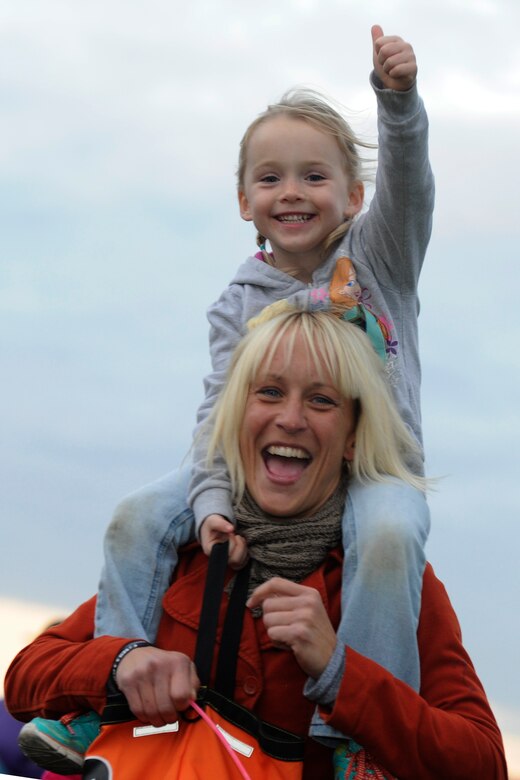 Rebecca Fowler, wife of Tech Sgt. Jeremy Fowler, 11th Security Forces Support Squadron and their daughter, walk around the Military Personnel Flight track during the Zombie Apocalypse Run on Joint Base Andrews, Md, Oct. 30, 2014. Military Families around the National Capital Region were invited to attend “Trunk or Treat” and the Zombie Apocalypse Run in celebration of Halloween. (U.S. Air Force photo/ Senior Airman Nesha Humes)