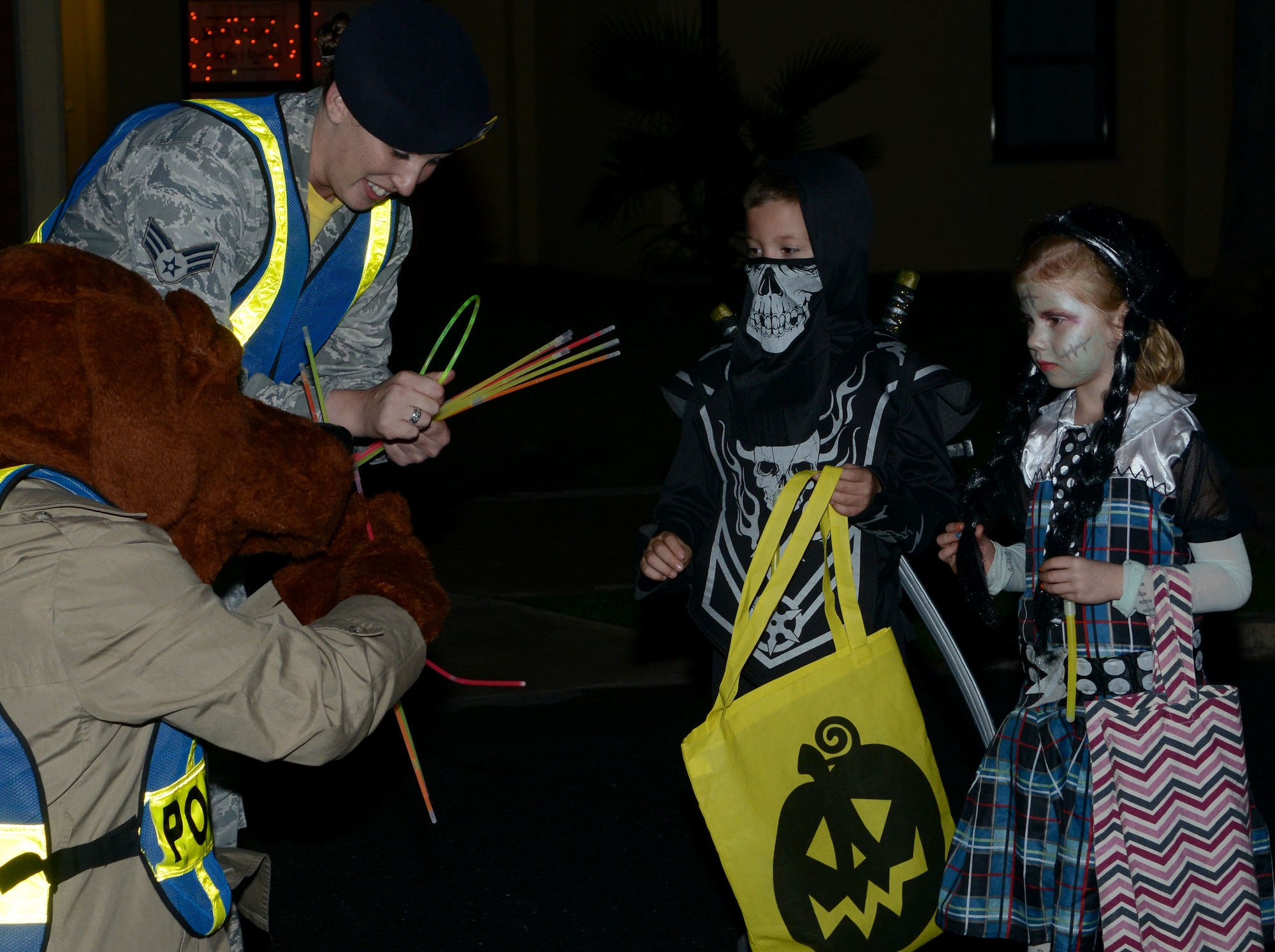 Members of the 39th Security Forces Squadron, along with McGruff the Crime Dog, pass out glow sticks and candy during Pumpkin Patrol Oct. 31, 2014, at Incirlik Air Base, Turkey. Pumpkin Patrol is an event hosted by the 39th SFS, where defenders patrol through base housing and gave out candy and glow sticks on Halloween night. (U.S. Air Force photo by Staff Sgt. Caleb Pierce/Released)