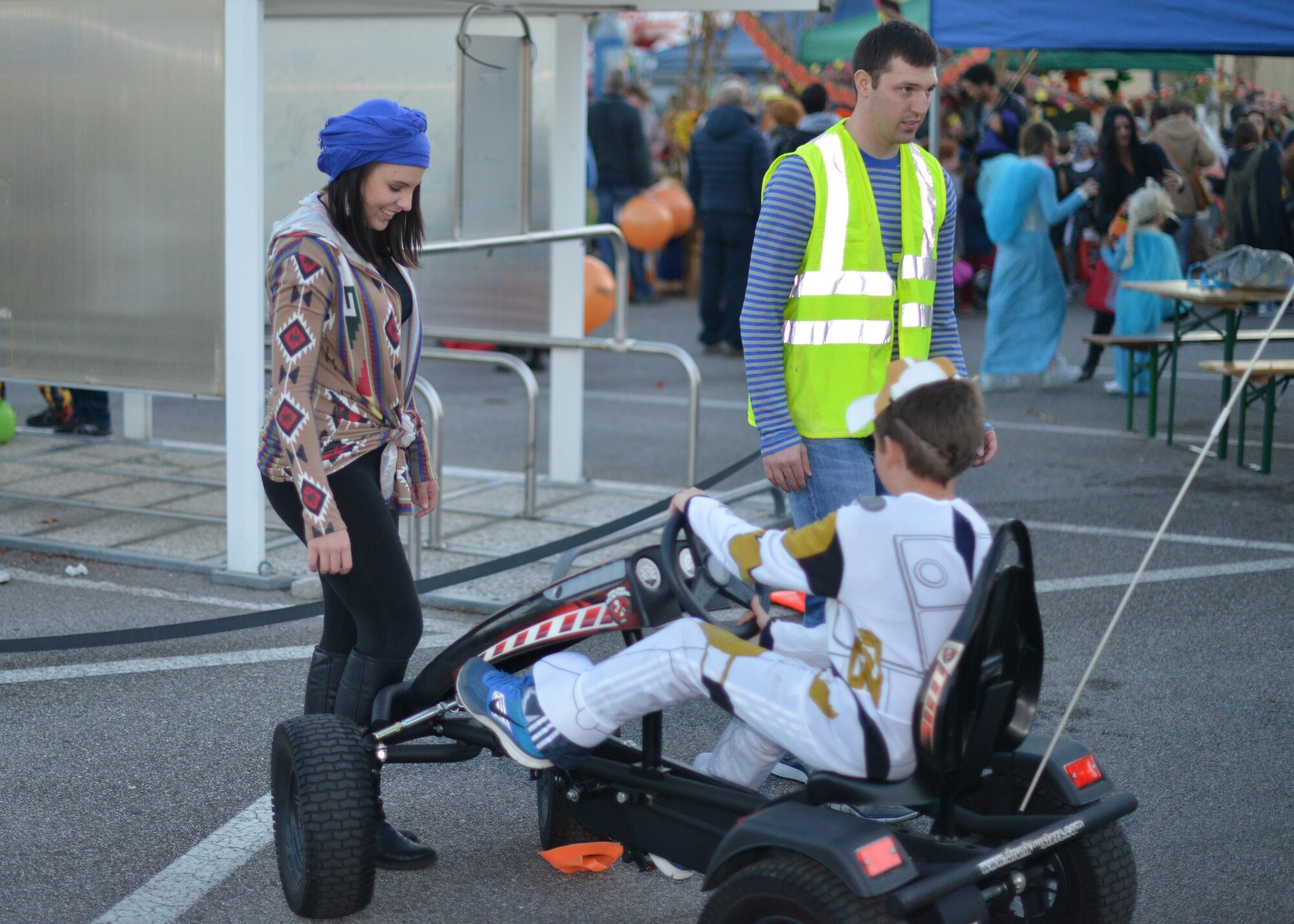 Airman 1st Class Deana Heitzman, Aviano Against Drunk Driving vice president, assists a child while parking a pedal car at the AADD booth at Fall Fest, November 1, 2014, at Aviano Air Base, Italy. Fall Fest offered Department of Defense cardholders and their families a chance to celebrate Halloween in a fun and safe environment. While at Fall Fest, families enjoyed trick-or-treat-booths, food stands, a costume parade and carnival games.  (U.S. Air Force photo/Tech. Sgt. Eric Donner)