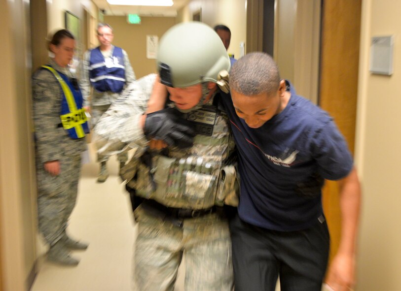 Tech. Sgt. Jeffrey Lucas, 2nd Security Forces Squadron installation patrolman, assists a simulated victim during an active shooter exercise on Barksdale Air Force Base, La., Oct. 26, 2014. Once the initial threat is removed, security forces perform a sweep looking for any injured individuals and move them to a safe location for treatment. (U.S. Air Force photo/Airman 1st Class Mozer O. Da Cunha)