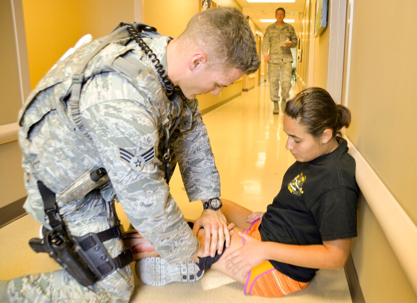 Senior Airman Mark Witt, 2nd Security Forces Squadron installation patrolman, performs self-aid buddy care on a simulated victim during an active shooter exercise on Barksdale Air Force Base, La., Oct. 26, 2014. Personnel perform SABC on victims with severe injuries prior to removing them from a scene. (U.S. Air Force photo/Airman 1st Class Mozer O. Da Cunha)