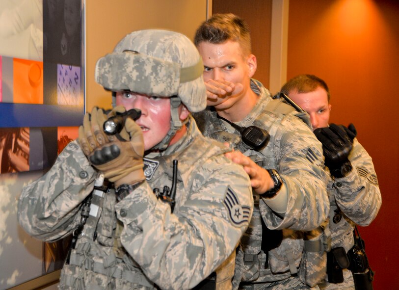 Airmen from the 2nd Security Forces Squadron, tactically move down a hallway during an active shooter exercise on Barksdale Air Force Base, La., Oct. 26, 2014. Once the primary threat is removed, Airmen perform a hallway and room check to verify no secondary threats are present. (U.S. Air Force photo/Airman 1st Class Mozer O. Da Cunha)