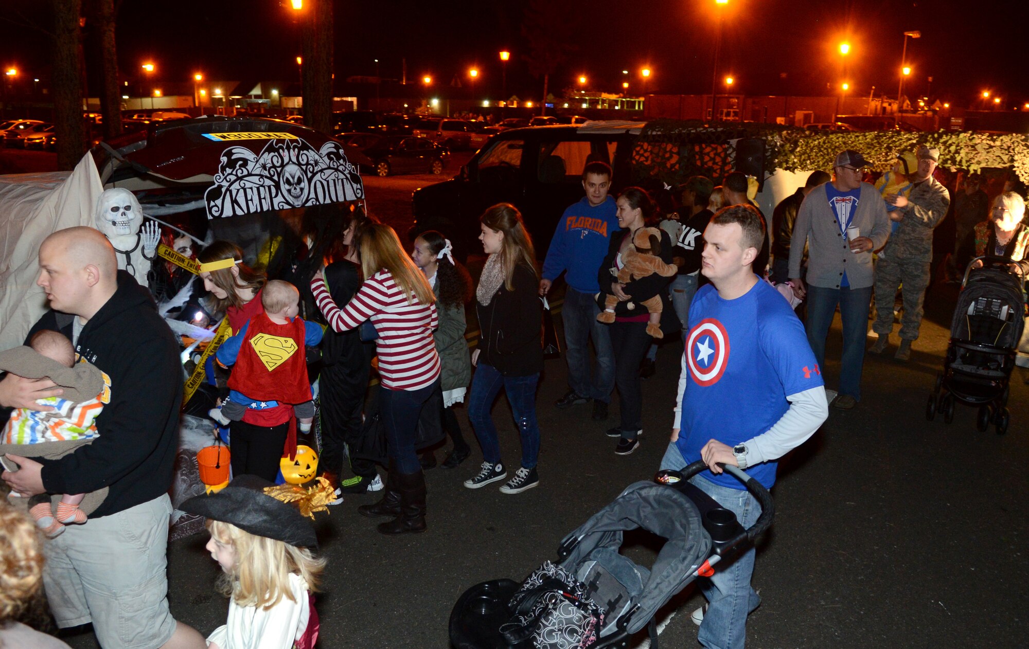 Team Mildenhall members enter the “Trunk or Treat” event area Oct. 31, 2014, on RAF Mildenhall, England. Children dressed up in costumes and received candy and treats from volunteers who used the backs of their cars to create an easily accessible trick-or-treat venue for Team Mildenhall children. (U.S. Air Force photo by Airman 1st Class Dillon Johnston/Released)