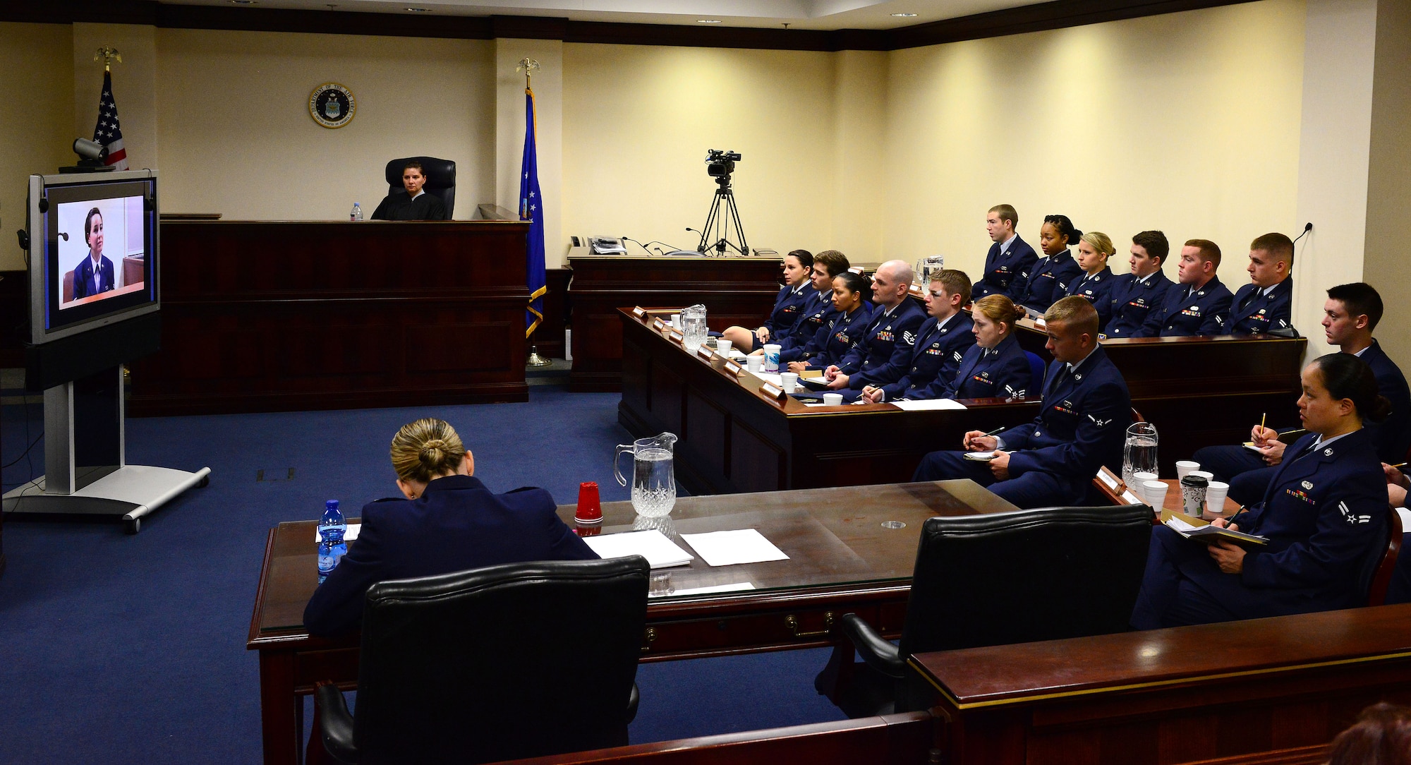 Airmen from the 31st Fighter Wing listen to video testimony during the sexual assault mock trial, Oct. 28, 2014, at Aviano Air Base, Italy. Participants watched a recreated video testimony of the victim describing the events that led to the alleged attack. (U.S. Air Force photo/Senior Airman Matthew Lotz)