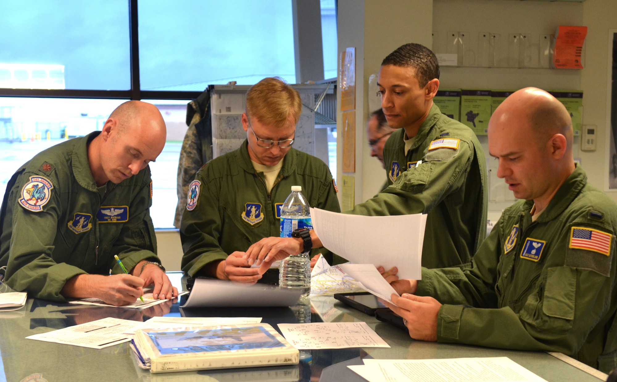 Pilot and mission commander U.S. Air Force Maj. Troy Bockius, combat systems officer (CSO) Maj. Roy Shoppert, pilot Lt. Col. J.D. Davis (background), pilot 1st Lt. Chris Farrell and CSO 1st Lt. Alex Sutherland, all from the 142nd Airlift Squadron, 166th Airlift Wing, Delaware Air National Guard at a mission planning meeting for a two-ship C-130H formation and airdrop mission on Oct. 22, 2014 at the New Castle ANG Base, Del. (U.S. Air National Guard photo by Tech. Sgt. Benjamin Matwey)
