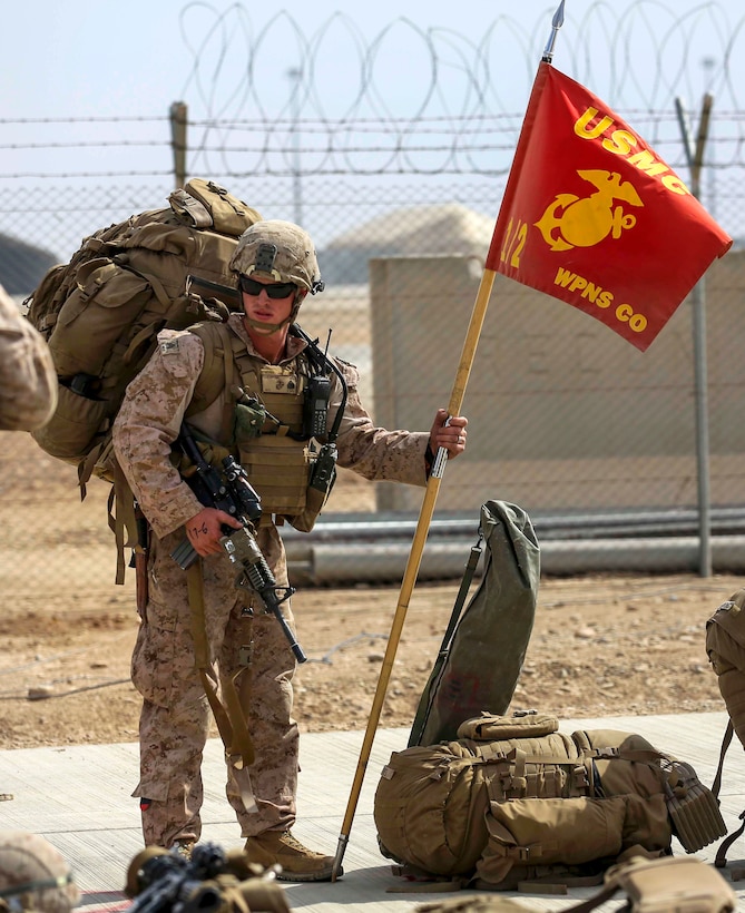 U.S. Marine Corps Sgt. William Galentine holds a unit’s guidon while waiting to depart Camp Leatherneck, Helmand province, Afghanistan, Oct. 27, 2014. Galentine is assigned to Weapons Company, 1st Battalion, 2d Marine Regiment.
