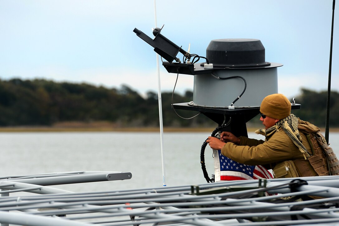 Navy Petty Officer 3rd Class Zachary Feldhege attaches the U.S. flag to the mast of a 34-foot patrol boat before departing for a training exercise during exercise Bold Alligator 2014 near Marine Corps Air Station New River in Jacksonville, N.C., Nov. 1, 2014. Feldhege is a quartermaster assigned to Coastal Riverine Squadron 4.