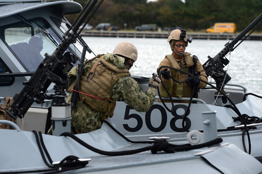 Navy Petty Officer 3rd Class Kayla Lewis, right, casts off the forward mooring line of a 34-foot patrol boat during exercise Bold Alligator 2014 near Marine Corps Air Station New River in Jacksonville, N.C., Nov. 1, 2014. Lewis is a boatswain's mate assigned to Coastal Riverine Squadron 4.