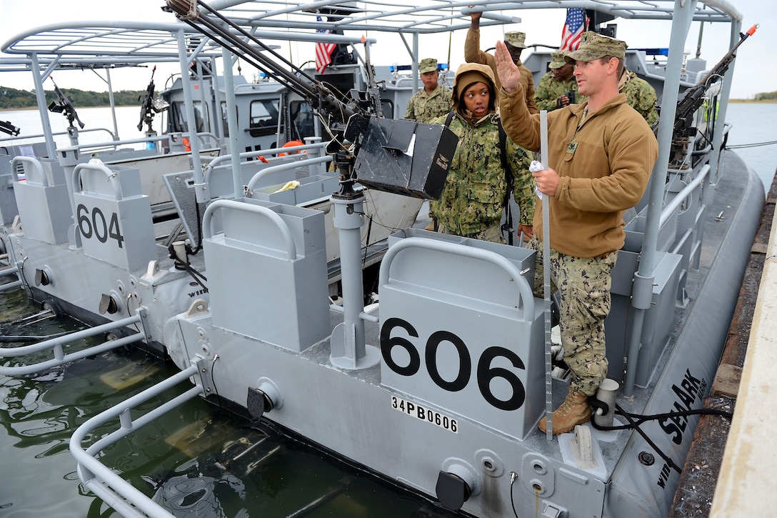 Navy Petty Officer 2nd Class Jacob Miller, right, conducts training with Navy Seaman Simone Street on the mechanics of a 34-foot patrol boat during exercise Bold Alligator 2014 near Marine Corps Air Station New River in Jacksonville, N.C., Nov. 1, 2014. Miller is an engineman, and Street is a master-at arms assigned to Coastal Riverine Squadron 4.