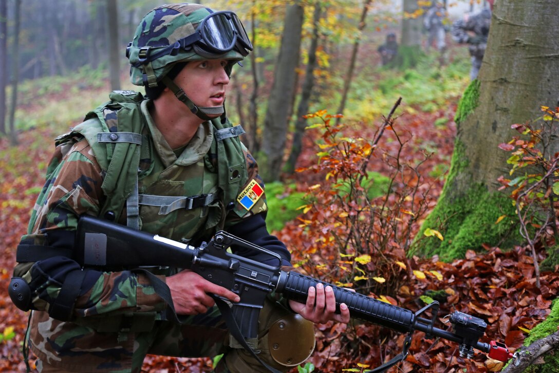 A Moldovan soldier provides security while conducting a company ...