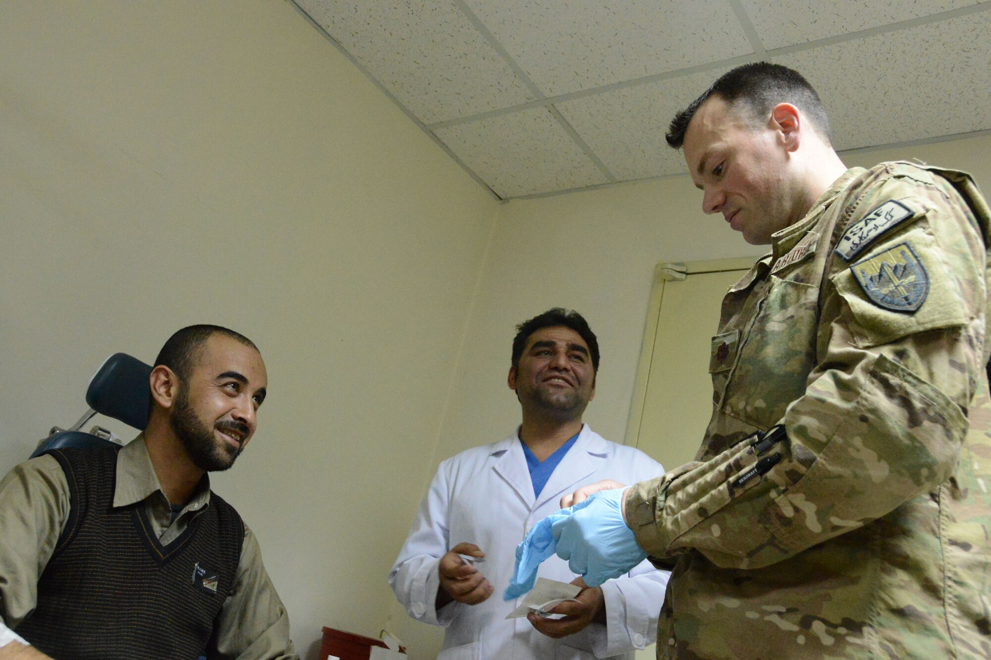 U.S. Air Force Maj. Jonathan Forbes, a neurosurgeon assigned to the 455th Expeditionary Medical Group and a native of New Martinsville, West Virginia, prepares to examine the healing process of a patient Oct. 22, 2014. Forbes, deployed from Travis Air Force Base, Calif., removed a tumor from the man’s brain 12 days earlier. (U.S. Air Force photo by Master Sgt. Cohen A. Young/Released)