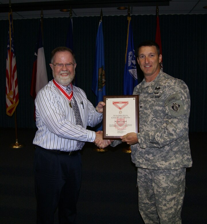 Tulsa District Commander, Col. Richard A. Pratt, presents the bronze de Fleury Medal to John Marnell, deputy chief of Operations Division.