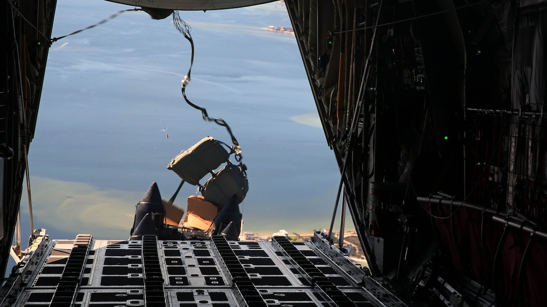 Two Combat Rubber Raiding Craft drop out the back of a KC-130J Super Hercules during an aerial delivery mission at near Hurlburt Air Force Base, Fla., Oct. 24, 2014. The training was conducted in support of United States Special Operations Command. The Hercules belongs to Marine Aerial Refueler Transport Squadron 252.