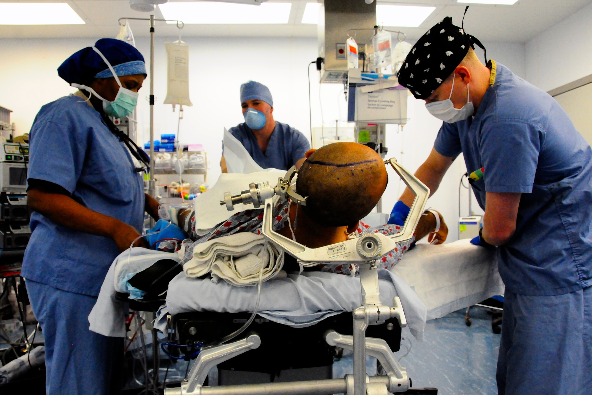 Maj Clara Batiste, a certified registered nurses assistant, Capt Michael Tiger, an anesthesiologist, and Maj Jonathan Forbes, neurosurgeon with the 455th Expeditionary Medical Operations Squadron, prepare a patient for brain surgery Oct. 10, 2014, at the Craig Joint Theater Hospital, Bagram Airfield, Afghanistan. Forbes removed an 8 centimeter tumor from the patient’s brain. Batiste is deployed from Fort Sam Houston, Texas. Forbes and Tiger are deployed from Travis Air Force Base, Calif. (U.S. Air Force photo/Staff Sgt. Miguel Lara III)