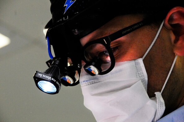 Maj. Jonathan Forbes looks through loupes as he performs brain surgery Oct. 10, 2014, at the Craig Joint Theater Hospital, Bagram Airfield, Afghanistan. The loupes allow Forbes to see greater detail while performing surgery. Forbes removed an 8 centimeter tumor during the 5-hour surgery. Forbes is a 455th Expeditionary Medical Operations Squadron neurosurgeon. (U.S. Air Force photo/Staff Sgt. Miguel Lara III)