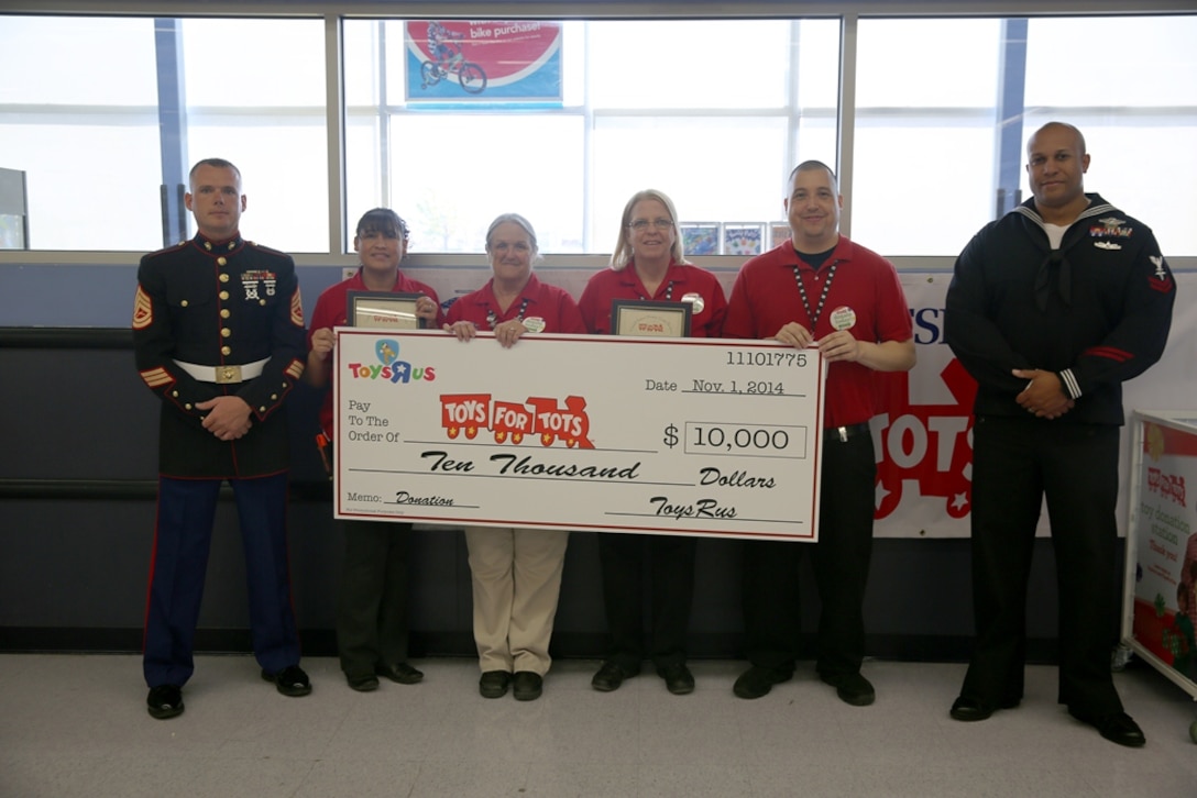 (Left) Gunnery Sergeant Jeffery Worely, Toys for Tots Staff Noncommissioned Officer with Headquarters Battalion on Marine Corps Logistics Base Barstow, Calif., (middle right) Theresa Boylen, store director of Toys “R” Us in Victorville, Calif., and here employees, (far right) Petty Officer 2nd Class Jeffrey Archie, hospital corpsman here, pose with a 10,00 dollar check for the Toys for Tots Foundation in Toys “R” Us, Victorville, Calif., Nov. 1. 
