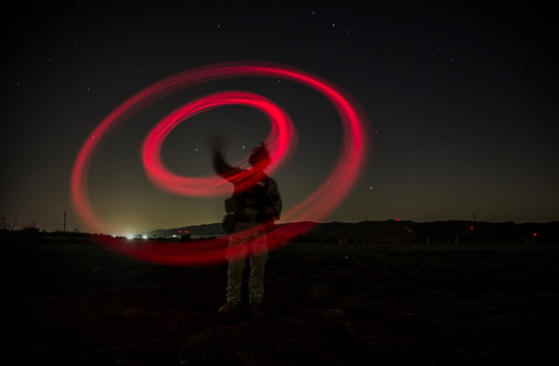 A U.S. Marine with Lima Company, Battalion Landing Team 3rd Battalion, 1st Marine Regiment, 15th Marine Expeditionary Unit, signals the landing zone for an MV-22B Osprey aircraft using the “buzz saw” method during a vertical assault raid exercise aboard Camp Pendleton, Calif., Oct. 27, 2014. BLT 3/1 is the 15th MEU’s ground combat element. (U.S. Marine Corps photo by Sgt. Emmanuel Ramos/Released)