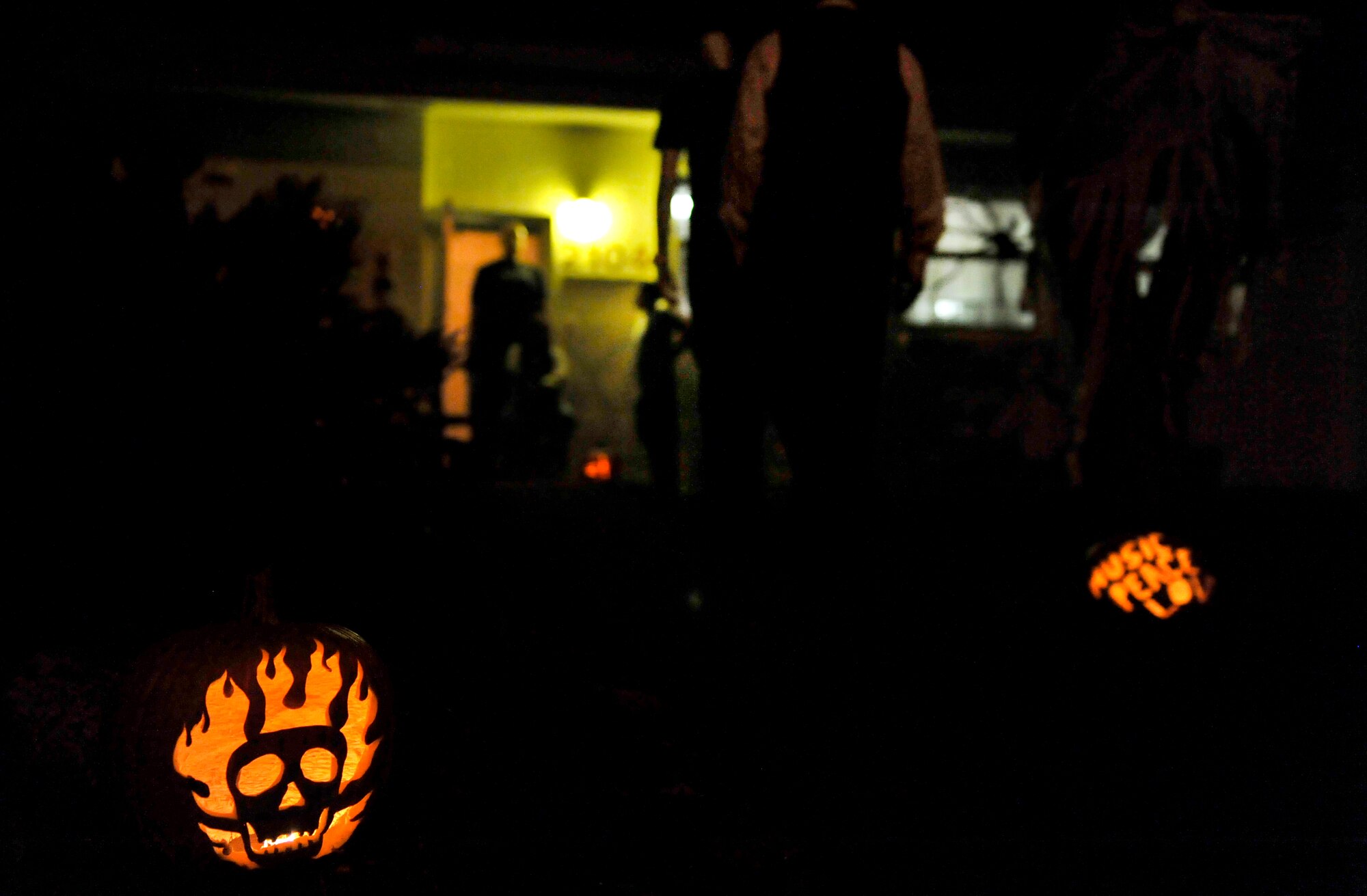 Jack-O'-Lanterns illuminate a path toward candy for trick-or-treaters during Halloween on Kadena Air Base, Japan, Oct. 31, 2014. A Jack-O'-lantern is a carved pumpkin, or turnip, associated chiefly with the holiday of Halloween, and was named after the phenomenon of strange light flickering over peat bogs, called will-O'-the-wisp or Jack-O'-lantern. (U.S. Air Force photo by Naoto Anazawa/Released)