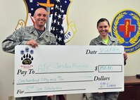Airman 1st Class Jeslyn Macon, 341st Medical Operations Squadron, right, receives a scholarship for $150 from the Big Sky Top 3 Oct. 31. Master Sgt. James Nephew, 341st Security Forces Squadron, presents the check on behalf of the Big Sky Top 3. The third quarter scholarship was awarded based on an essay topic addressing ways Airmen at Malmstrom have embraced ‘A Call to Excellence.’  Macon’s essay was chosen from a total of ten submissions. (U.S. Air Force photo/ John Turner)