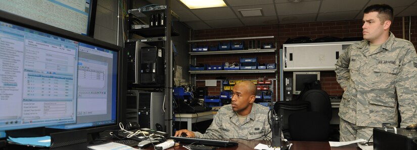 Airman 1st Class Jeshurun Marbury (left) and Senior Airman James Owens, 744 Communication Squadron radio frequency technicians, examine an access control point for a land-to-mobile radio trunking system at the 744 CS building here on Aug. 26, 2014. The 744 CS is responsible for LMR communications, the giant voice and public address system. (U.S. Air Force photo/Airman 1st Class Joshua R. M. Dewberry)